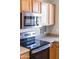 Close-up view of the stainless steel microwave and glass top stove in this upgraded kitchen at 1349 E Dunbar Dr, Phoenix, AZ 85042