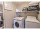 Functional laundry room with white appliances and shelving for storage at 1349 E Dunbar Dr, Phoenix, AZ 85042