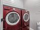 Laundry room features a modern red washer and dryer set with overhead shelving at 1366 W Santa Gertrudis Trl, San Tan Valley, AZ 85143