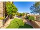 Well-maintained backyard with artificial turf, a stone wall, and mature landscaping for ultimate privacy at 15827 E Firerock County Club Dr, Fountain Hills, AZ 85268