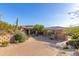 Paver driveway leading to a well-maintained home with mature trees, desert plants, and multiple garages at 15827 E Firerock County Club Dr, Fountain Hills, AZ 85268
