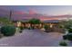 Stunning home exterior with a well-manicured front yard and a paver driveway at dusk at 15827 E Firerock County Club Dr, Fountain Hills, AZ 85268