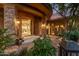 Elegant home entrance boasts stone pillars, decorative lighting, and a glimpse into the chandelier-lit foyer at 15827 E Firerock County Club Dr, Fountain Hills, AZ 85268