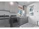 Well-lit laundry room with gray cabinets, modern washer and dryer, and a convenient utility sink at 15827 E Firerock County Club Dr, Fountain Hills, AZ 85268