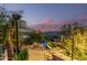 Scenic pool area featuring lush landscaping, a cozy fire pit, and views of the lake and mountains at 15827 E Firerock County Club Dr, Fountain Hills, AZ 85268