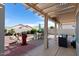 Spacious backyard featuring outdoor seating under a pergola, a barbecue, and a charming waterfall feature at 15876 W Alpine Ridge Dr, Surprise, AZ 85374