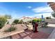 Backyard with desert landscaping, a barbeque grill, a waterfall feature, and outdoor dining set at 15876 W Alpine Ridge Dr, Surprise, AZ 85374