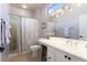 Well-lit bathroom featuring a shower stall, toilet and a sink with a mirror at 15876 W Alpine Ridge Dr, Surprise, AZ 85374