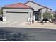 Charming single-story home with tile roof, landscaped front yard, and an attached two-car garage at 15876 W Alpine Ridge Dr, Surprise, AZ 85374