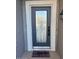Stylish front door with glass detail, welcoming mat, and modern hardware, exterior lighting at 15876 W Alpine Ridge Dr, Surprise, AZ 85374