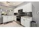 Contemporary kitchen with white cabinetry, stainless steel oven and grey stone backsplash at 15876 W Alpine Ridge Dr, Surprise, AZ 85374