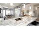 Spacious kitchen island with granite countertops, stainless steel sink, and view of the dining area at 15876 W Alpine Ridge Dr, Surprise, AZ 85374