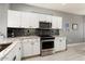 Bright kitchen featuring white cabinets, stainless steel appliances, and a stylish backsplash at 15876 W Alpine Ridge Dr, Surprise, AZ 85374