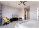 Comfortable main bedroom with lilac walls, carpet, ceiling fan, and entertainment center at 15876 W Alpine Ridge Dr, Surprise, AZ 85374