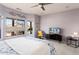 Main bedroom with carpet, fan, TV and windows overlooking the backyard at 15876 W Alpine Ridge Dr, Surprise, AZ 85374