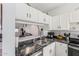Open kitchen with white cabinets and black marble countertops with modern stainless steel appliances at 1601 N Saba St # 264, Chandler, AZ 85225