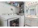 Functional laundry area boasts a Samsung washer/dryer set with shelving and adjacent vanity sink at 1601 N Saba St # 264, Chandler, AZ 85225