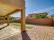 Covered backyard patio with concrete and brick flooring that looks out over artifical turf at 16247 W Desert Mirage Dr, Surprise, AZ 85379