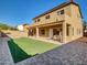 The backyard features a covered patio with artificial turf and brick accents, enclosed by a secure wall at 16247 W Desert Mirage Dr, Surprise, AZ 85379