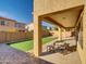 View of the backyard featuring a covered patio, artificial turf and brick accents, ideal for outdoor relaxation at 16247 W Desert Mirage Dr, Surprise, AZ 85379