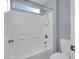 Bright and well-lit bathroom featuring a white tiled tub and shower with a window for natural light at 16247 W Desert Mirage Dr, Surprise, AZ 85379