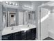 A well-lit bathroom features a double sink vanity, with a door to the toilet and a shower at 16247 W Desert Mirage Dr, Surprise, AZ 85379