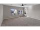 A spacious carpeted bedroom with three large windows and a ceiling fan at 16247 W Desert Mirage Dr, Surprise, AZ 85379
