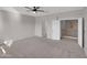 Spacious carpeted room with ceiling fan and an open doorway at 16247 W Desert Mirage Dr, Surprise, AZ 85379