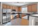 Bright kitchen features stainless steel appliances, wooden cabinets, and granite countertops at 16247 W Desert Mirage Dr, Surprise, AZ 85379