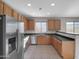 Kitchen features stainless steel appliances, tile floors, and wooden cabinets at 16247 W Desert Mirage Dr, Surprise, AZ 85379