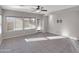 Bright open living room with tile floors, large windows, and a sliding glass door at 16247 W Desert Mirage Dr, Surprise, AZ 85379