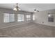 A large living room is brightly lit by sunlight shining through the windows at 16247 W Desert Mirage Dr, Surprise, AZ 85379