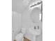 Bright powder room with pedestal sink, modern mirror, and a toilet at 16247 W Desert Mirage Dr, Surprise, AZ 85379