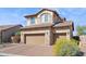 Two story home featuring a stone facade, brick driveway, and a three-car garage at 1646 N Channing --, Mesa, AZ 85207