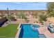Inviting backyard oasis featuring a sparkling pool, spa, lush greenery, and desert views at 1646 N Channing --, Mesa, AZ 85207