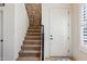 Carpeted staircase with stone accent wall and a white door at 1646 N Channing --, Mesa, AZ 85207