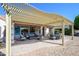 Covered patio with lounge seating, dining table and desert landscaping at 16495 W Monteverde Ln, Surprise, AZ 85374
