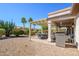 Expansive backyard patio with grill, dining, and mature landscaping at 16495 W Monteverde Ln, Surprise, AZ 85374