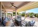 Covered backyard patio with ceiling fan, lounge seating, and dining set at 16495 W Monteverde Ln, Surprise, AZ 85374