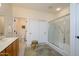 Bathroom features a shower with glass enclosure, sliding door closets, and a vanity with a cream countertop at 16495 W Monteverde Ln, Surprise, AZ 85374