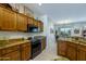 Kitchen boasts custom wood cabinetry, granite countertops, and stainless steel appliances including a black oven at 16495 W Monteverde Ln, Surprise, AZ 85374