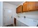 Bright laundry room with washer, dryer, sink, and storage cabinets at 16495 W Monteverde Ln, Surprise, AZ 85374