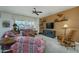 Comfortable living room with a ceiling fan, large windows, neutral carpet, and an entertainment center at 16495 W Monteverde Ln, Surprise, AZ 85374