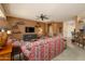 Bright living room featuring a ceiling fan, neutral carpet, and open access to the kitchen and entry at 16495 W Monteverde Ln, Surprise, AZ 85374