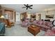 Open-concept living room with a ceiling fan, lots of seating, and access to the kitchen and entry at 16495 W Monteverde Ln, Surprise, AZ 85374