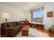 Cozy living room features a comfortable sofa, a large window, built-in shelves, and warm wood floors at 16495 W Monteverde Ln, Surprise, AZ 85374