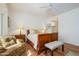 Bright main bedroom with hardwood floors features a ceiling fan and a view into the ensuite bathroom at 16495 W Monteverde Ln, Surprise, AZ 85374