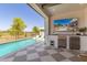 Covered backyard patio with a beautiful view of the swimming pool and the nearby green golf course at 17336 W Crawfordsville Dr, Surprise, AZ 85388
