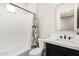 Bright bathroom featuring a shower-tub combo with a charming patterned curtain and a modern vanity with black hardware at 17336 W Crawfordsville Dr, Surprise, AZ 85388