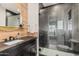 Modern bathroom boasts wood accent wall, sleek vanity, and spacious walk-in shower with decorative tile at 17336 W Crawfordsville Dr, Surprise, AZ 85388